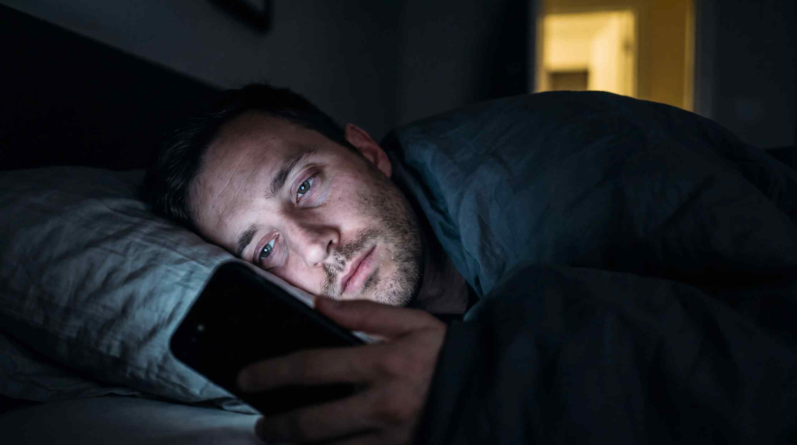 A man checking his phone before bed.